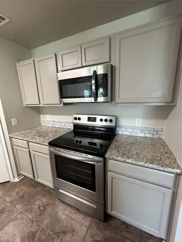 a kitchen with stainless steel appliances granite countertop a stove microwave and sink