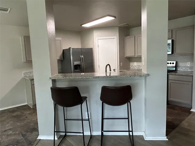 a kitchen with stainless steel appliances granite countertop a sink and a refrigerator