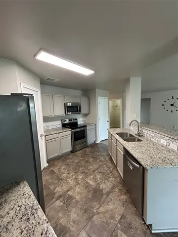 a kitchen with stainless steel appliances granite countertop a sink stove and refrigerator