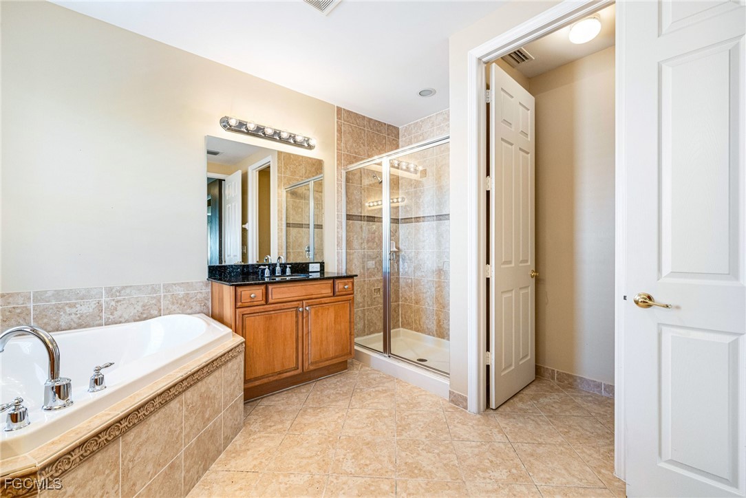 11196 Sand Pine Court Fort Myers, FL 33913 - Photo 18 of 49 a bathroom with a tub a sink and a mirror
