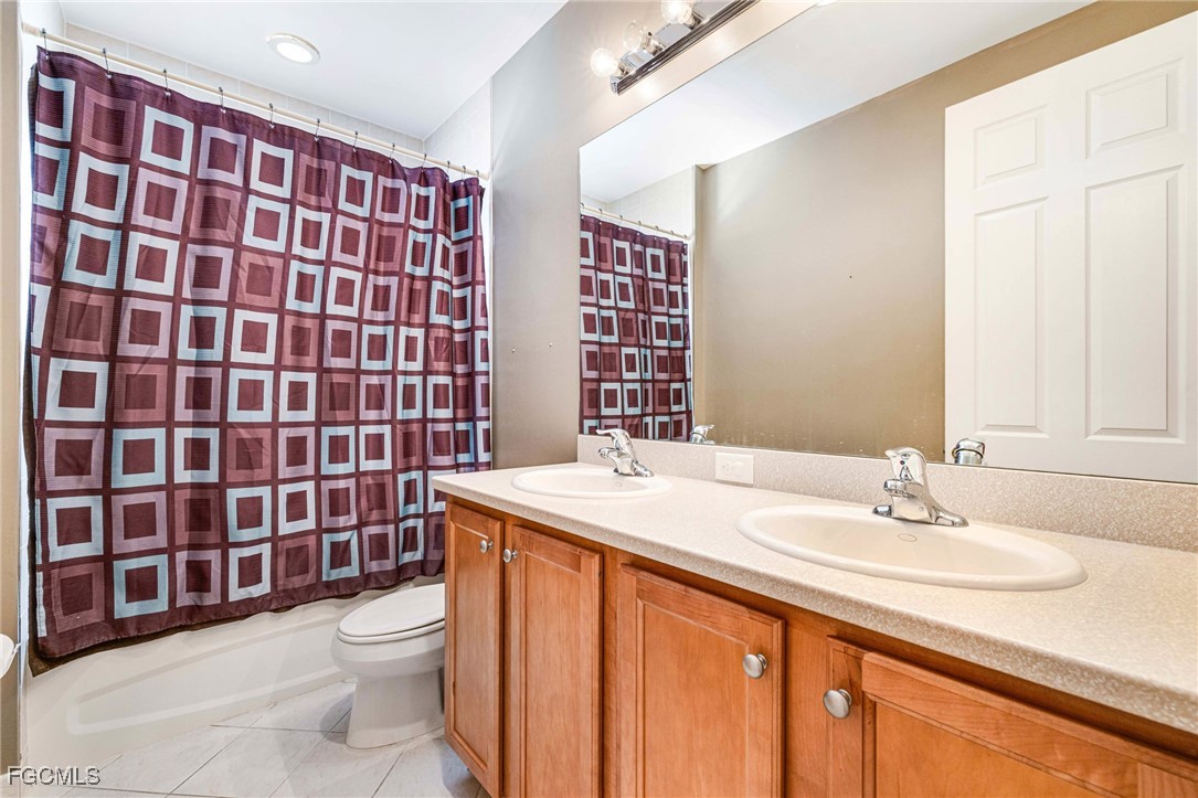11196 Sand Pine Court Fort Myers, FL 33913 - Photo 32 of 49 a bathroom with a sink a toilet and shower curtain
