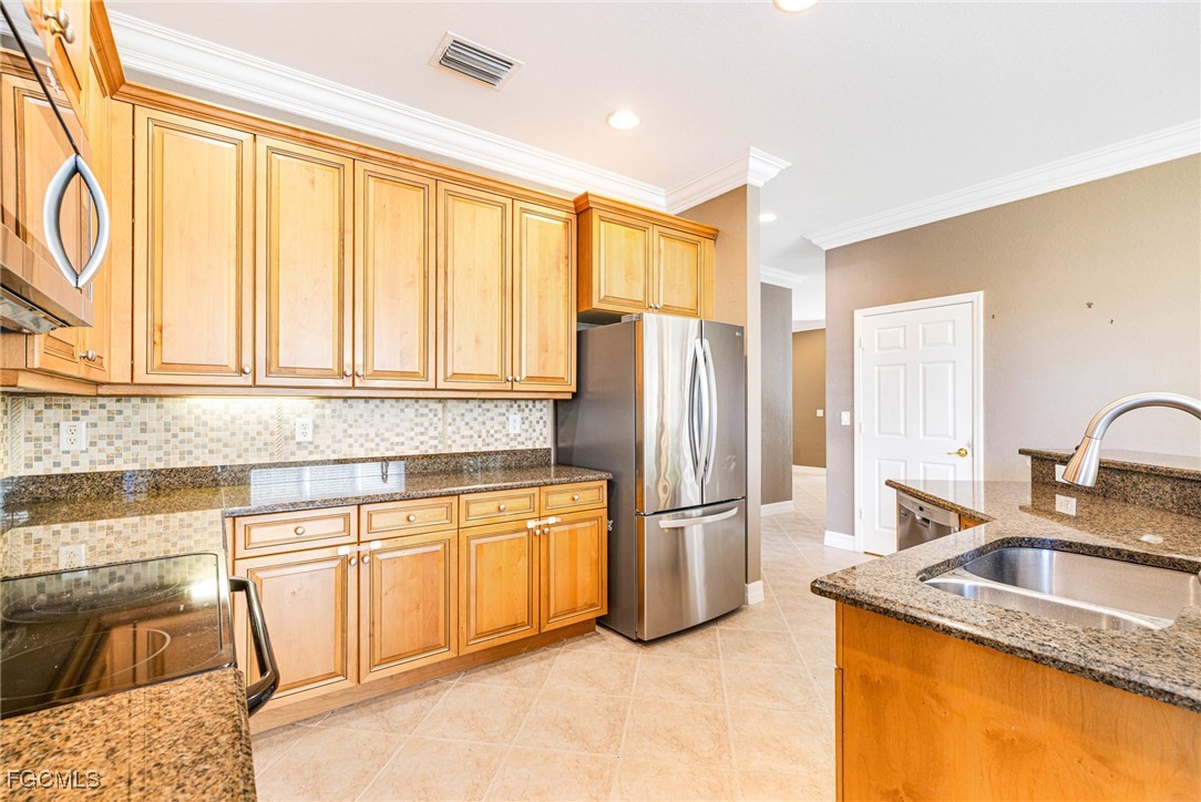 11196 Sand Pine Court Fort Myers, FL 33913 - Photo 9 of 49 a kitchen with granite countertop a refrigerator and a sink