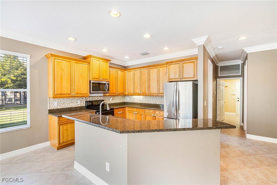 11196 Sand Pine Court Fort Myers, FL 33913 - Photo 10 of 49 a kitchen with stainless steel appliances granite countertop a sink a stove and a refrigerator with wooden floor