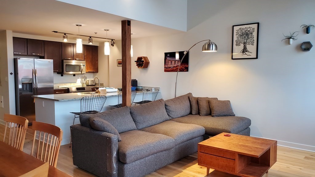 a living room with furniture kitchen view and a window