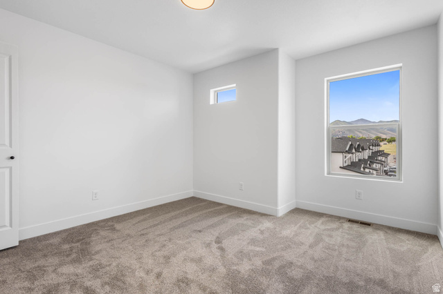 636 West Caroles Way, Unit 7 Tooele, UT 84074 - Photo 20 of 31 Neutral-toned carpeting paired with white walls, a contemporary ceiling light fixture, and two windows providing outdoor scenery