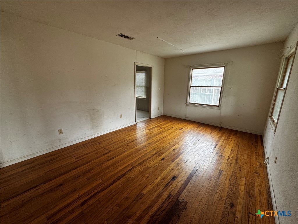 1010 South 17th Street Temple, TX 76504 - Photo 4 of 30 an empty room with wooden floor and windows