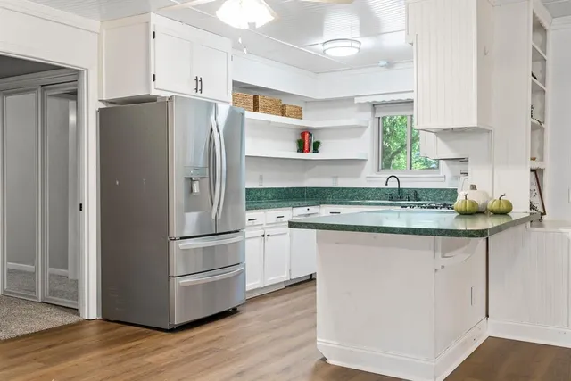 a kitchen with granite countertop a refrigerator and a sink