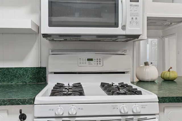 a white stove top oven sitting inside of a kitchen