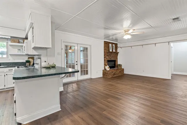 a kitchen with granite countertop a stove and a wooden floors