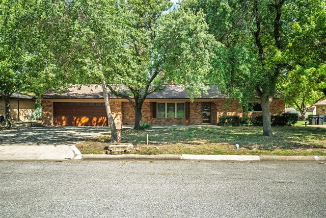 a view of a house with backyard and a tree