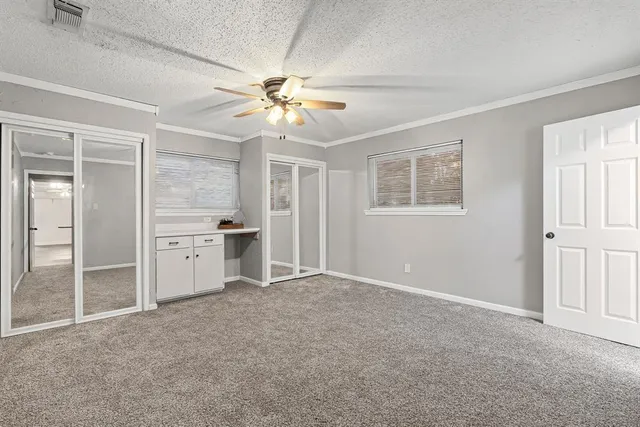 an empty room with windows and cabinet