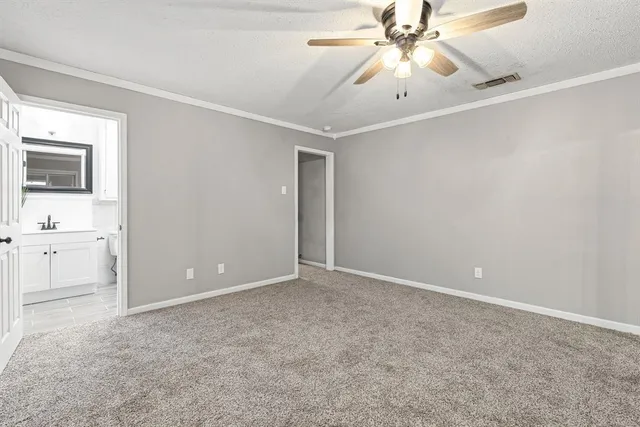a view of an empty room with a ceiling fan and a window