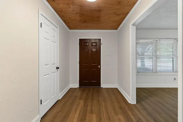 a view of a hallway with wooden floor and staircase