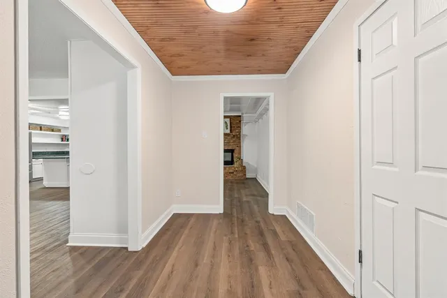 a view of a hallway with wooden floor and staircase