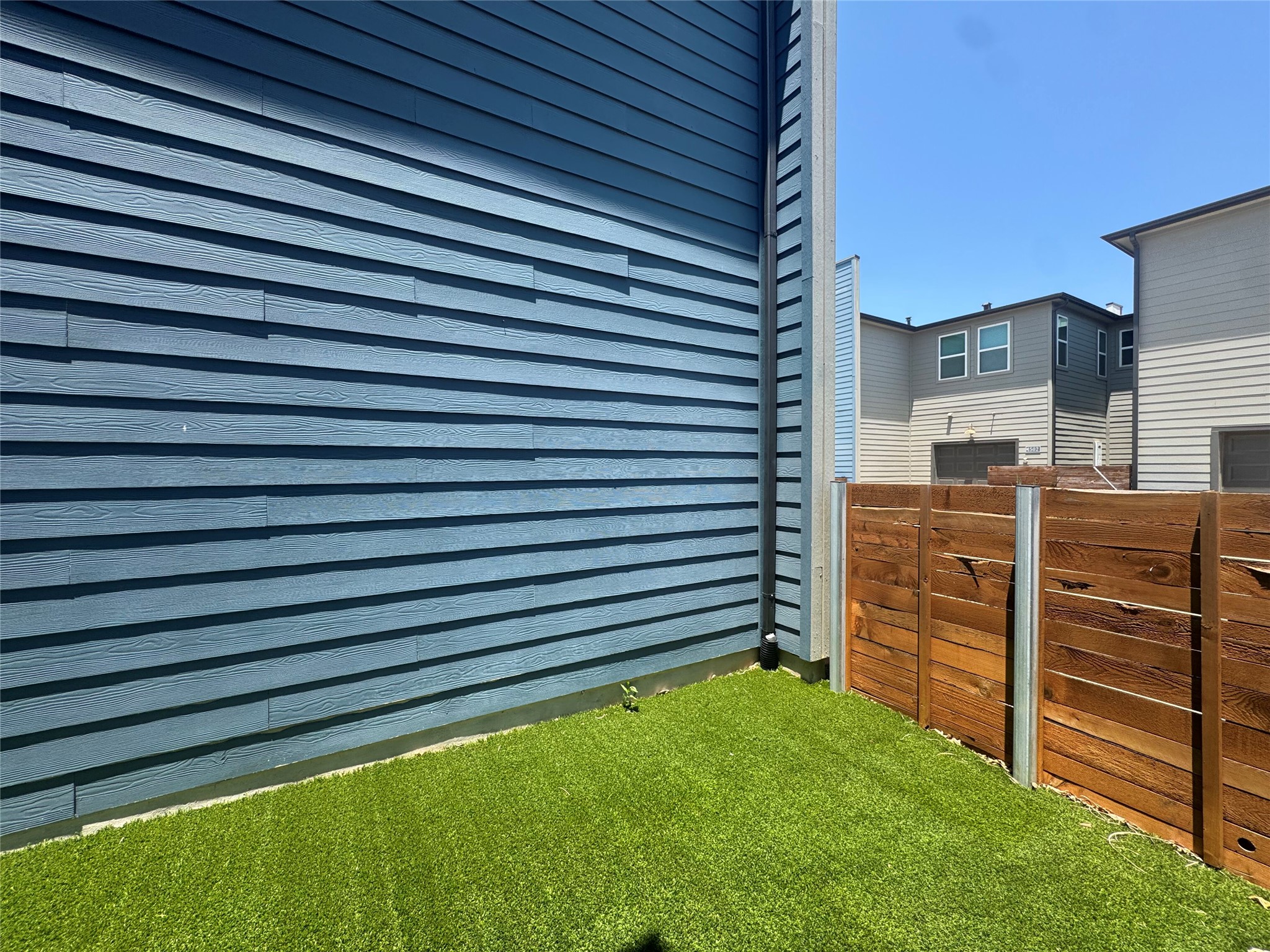 9015 Cattle Baron Path, Unit 2004 Austin, TX 78747 - Photo 26 of 27 fully fence small private yard space with artificial turf with access from private parking/garage space and separate back entrance into kitchen area