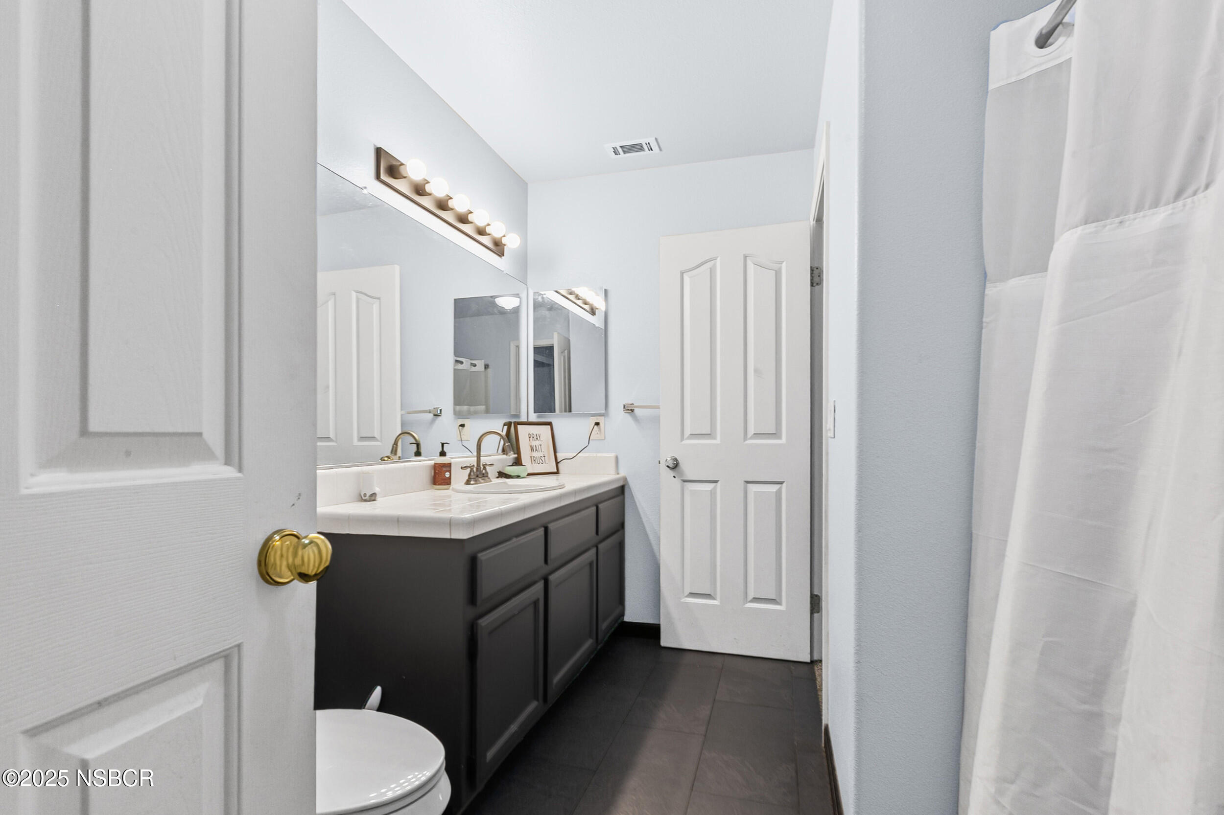 2442 Acacia Street Santa Maria, CA 93458 - Photo 19 of 27 a bathroom with a sink a toilet and mirror
