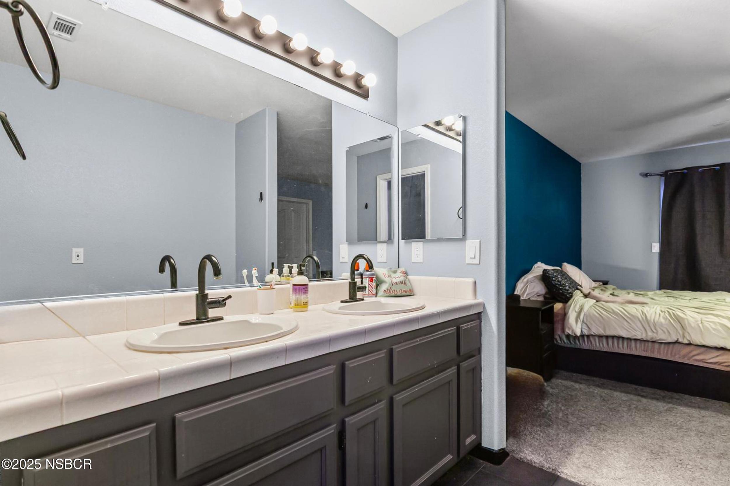 2442 Acacia Street Santa Maria, CA 93458 - Photo 26 of 27 a en suite bathroom with a double vanity sink and a mirror