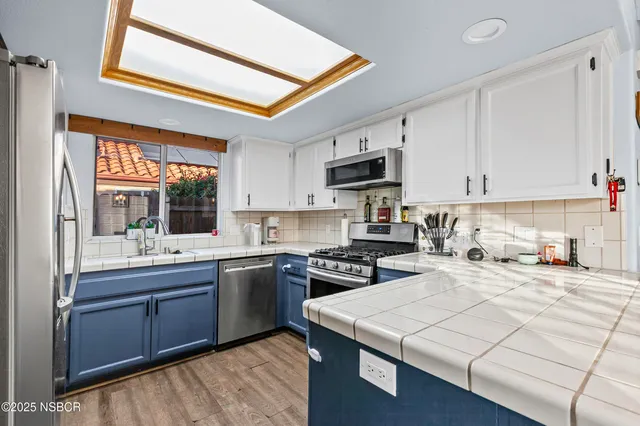 a kitchen with stainless steel appliances granite countertop a stove a sink dishwasher and a microwave oven with cabinets