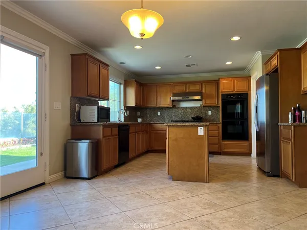 a kitchen with stainless steel appliances granite countertop a refrigerator a sink a stove top oven and a refrigerator