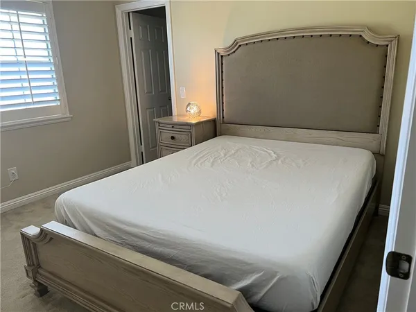 a bed sitting in a bedroom next to a window