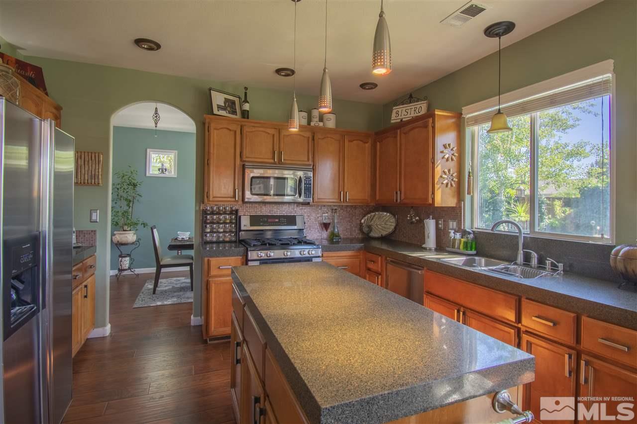 9621 Apache Rose Court Reno, NV 89521 - Photo 8 of 25 a kitchen with stainless steel appliances granite countertop a sink a stove counter space and cabinets