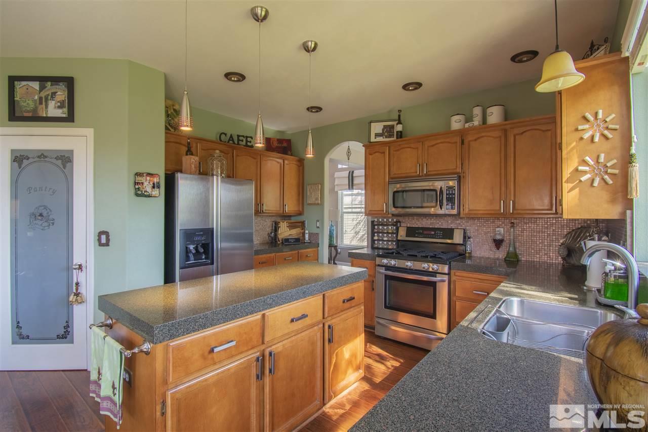 9621 Apache Rose Court Reno, NV 89521 - Photo 9 of 25 a kitchen with stainless steel appliances granite countertop a sink dishwasher stove and refrigerator