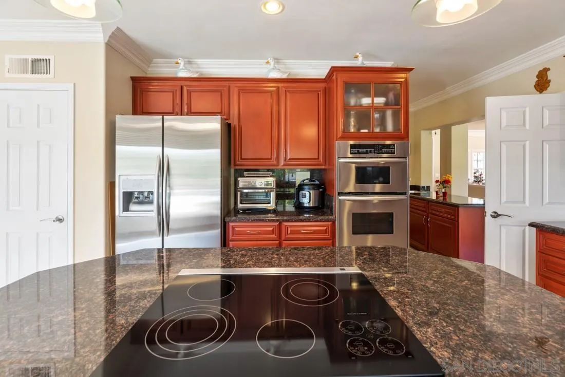 14513 Wildgrove Road Poway, CA 92064 - Photo 14 of 39 a kitchen with stainless steel appliances granite countertop a stove and a refrigerator