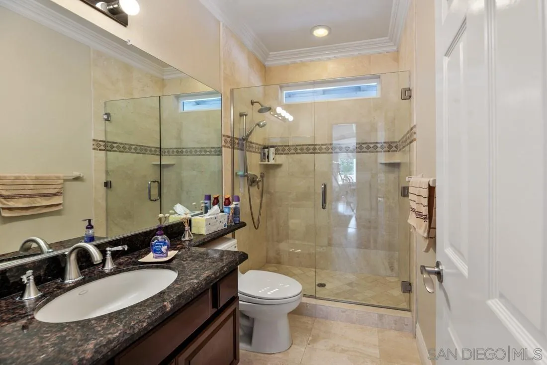 14513 Wildgrove Road Poway, CA 92064 - Photo 20 of 39 a bathroom with a granite countertop sink toilet a mirror and shower