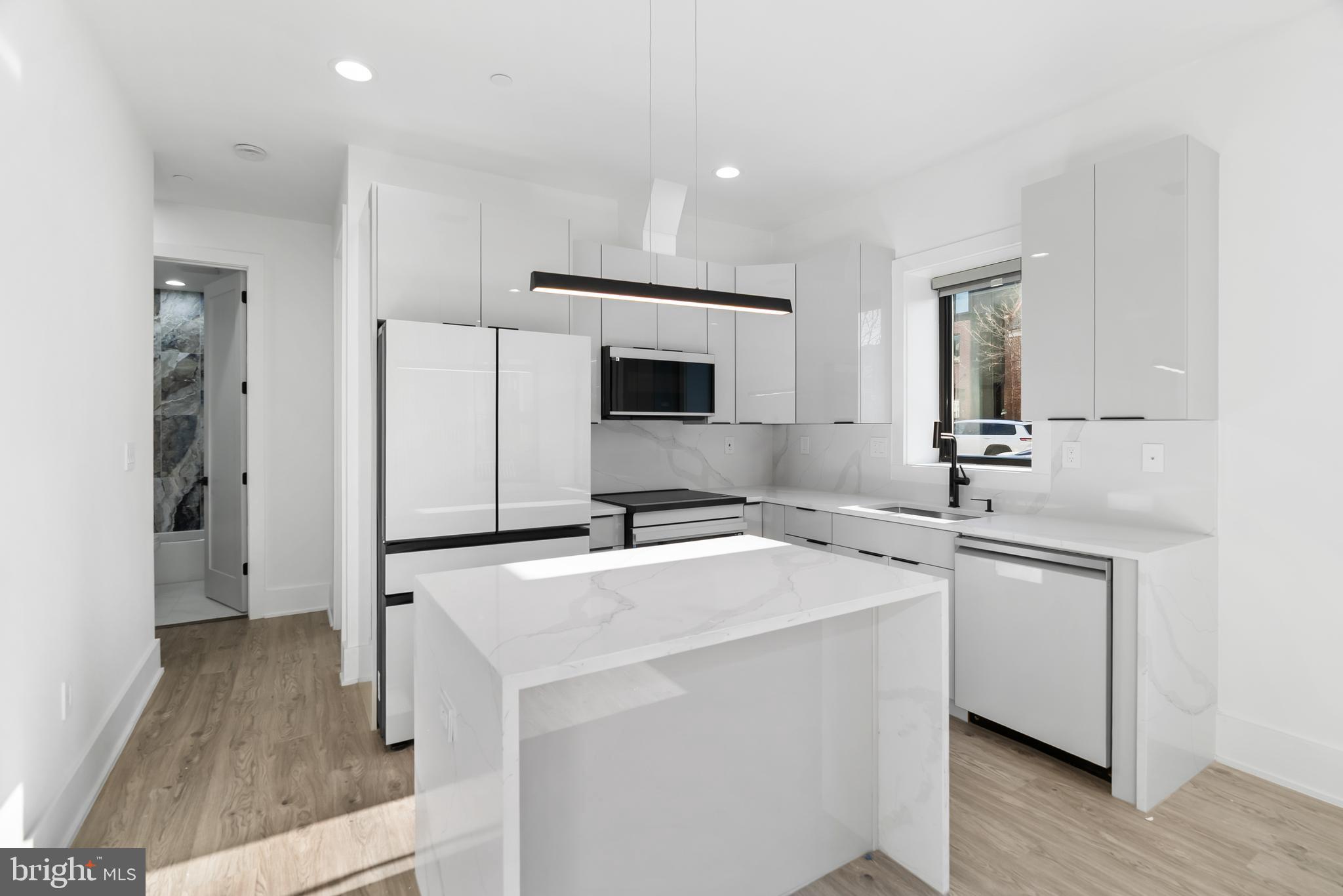 1140 Oates Street Northeast, Unit 102 Washington, DC 20002 - Photo 14 of 40 a kitchen with a sink a stove and refrigerator
