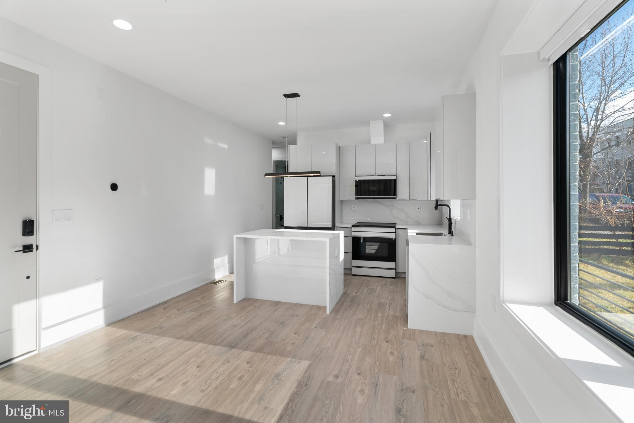 1140 Oates Street Northeast, Unit 102 Washington, DC 20002 - Photo 15 of 40 a kitchen with white cabinets and stainless steel appliances
