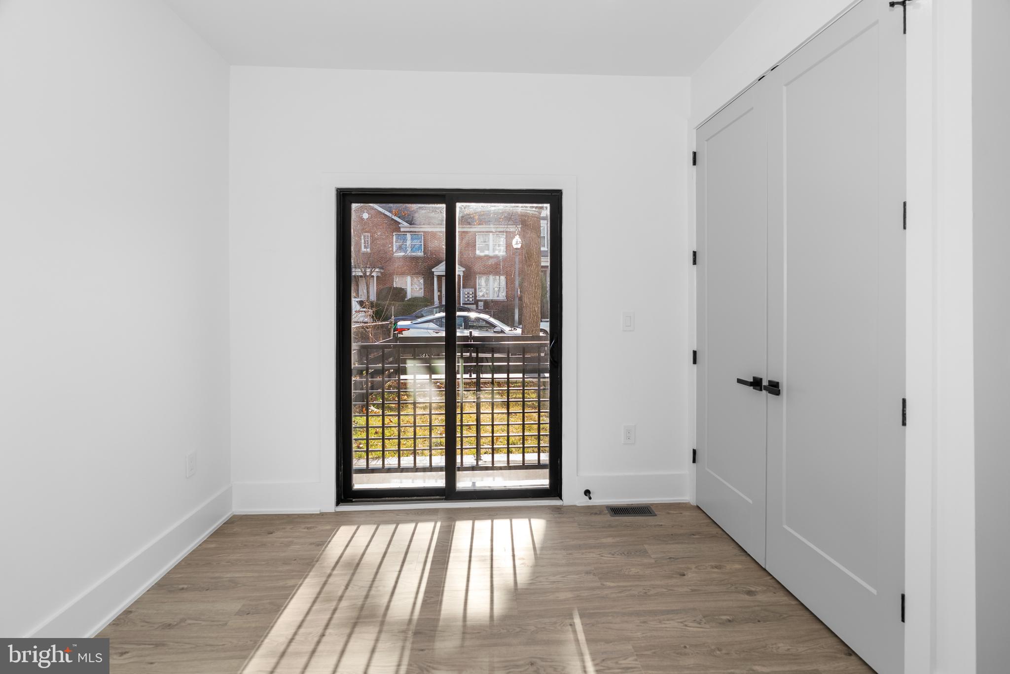 1140 Oates Street Northeast, Unit 102 Washington, DC 20002 - Photo 22 of 40 a view of an empty room with wooden floor and a window