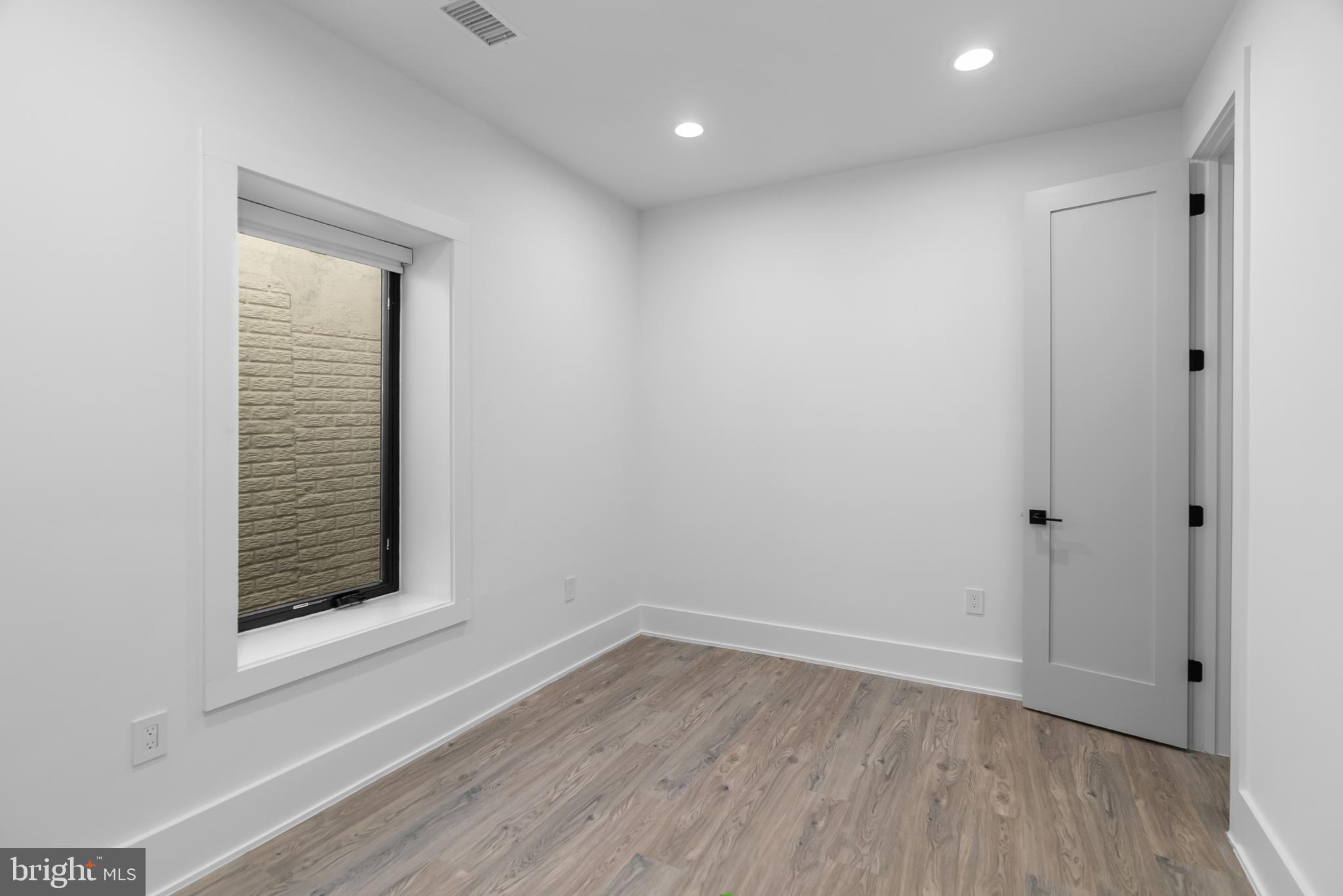 1140 Oates Street Northeast, Unit 102 Washington, DC 20002 - Photo 27 of 40 a view of an empty room with wooden floor and a window