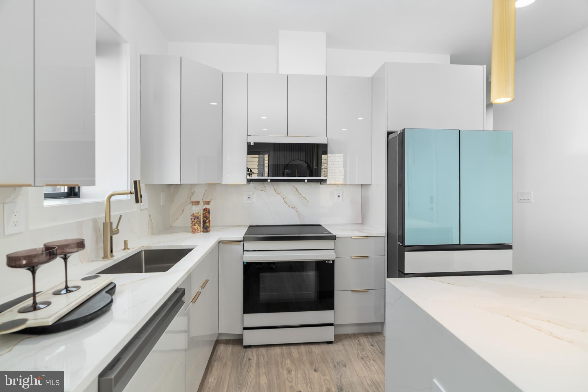 1140 Oates Street Northeast, Unit 102 Washington, DC 20002 - Photo 3 of 40 a kitchen with stainless steel appliances a stove a sink and a microwave