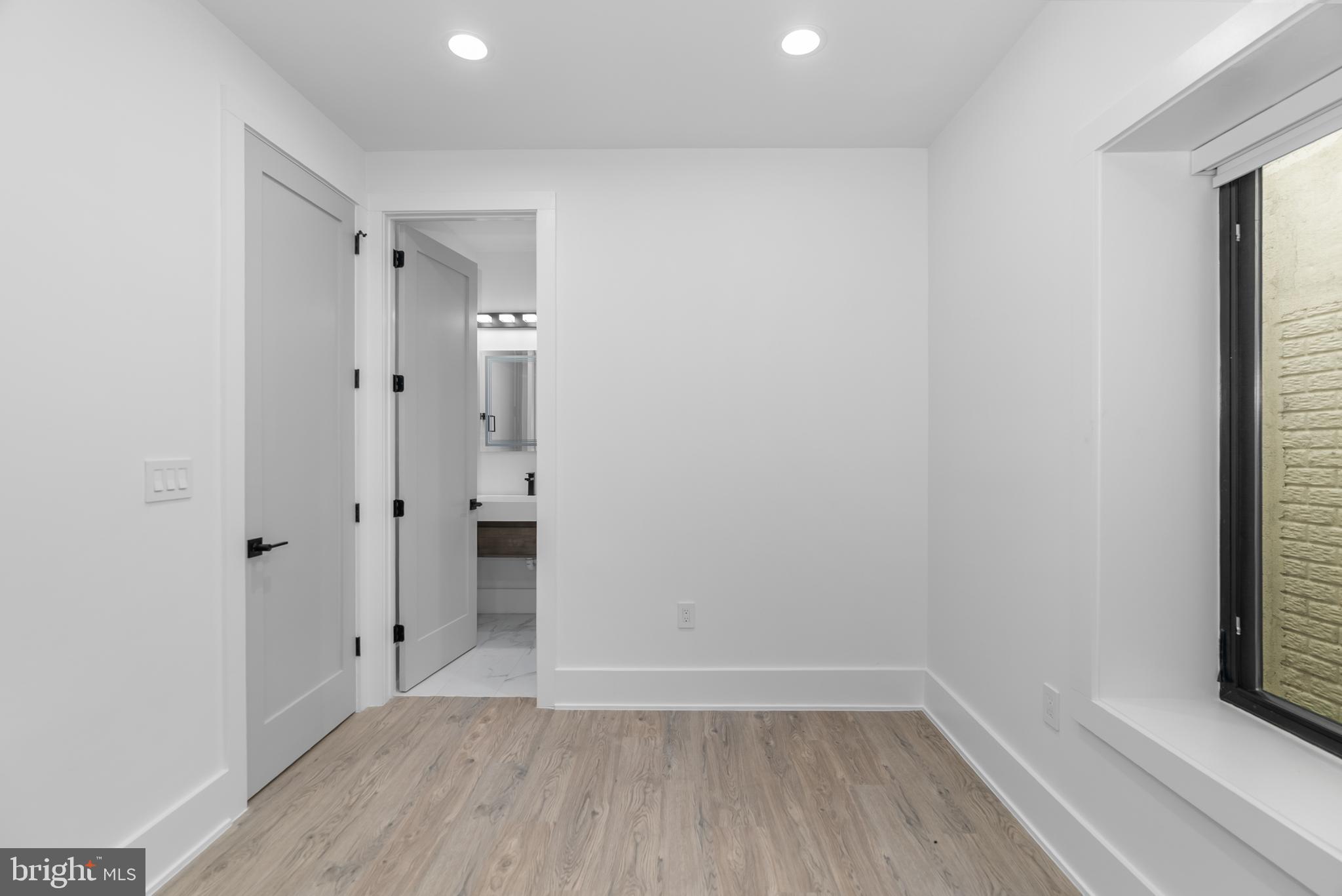 1140 Oates Street Northeast, Unit 102 Washington, DC 20002 - Photo 32 of 40 a view of an empty room with wooden floor and a window