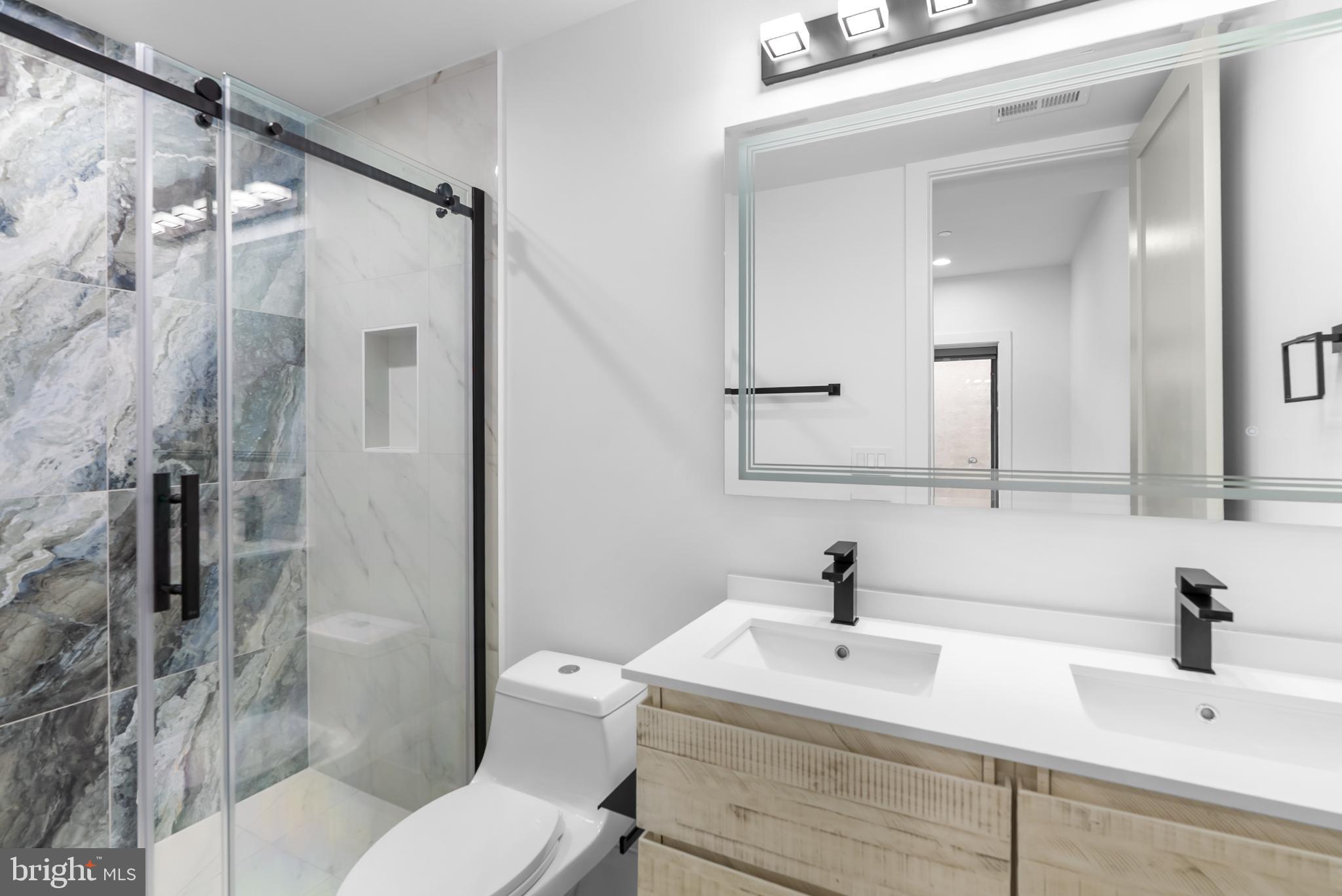 1140 Oates Street Northeast, Unit 102 Washington, DC 20002 - Photo 35 of 40 a bathroom with a sink toilet and shower