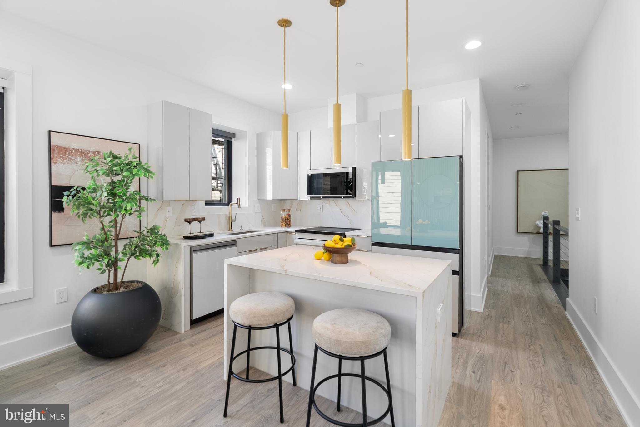 1140 Oates Street Northeast, Unit 102 Washington, DC 20002 - Photo 10 of 40 a kitchen with stainless steel appliances a refrigerator a sink a dining table and chairs