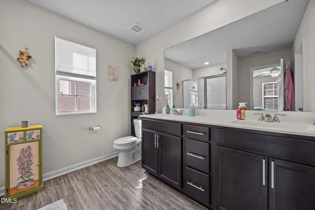 a bathroom with a double vanity sink a toilet and a window