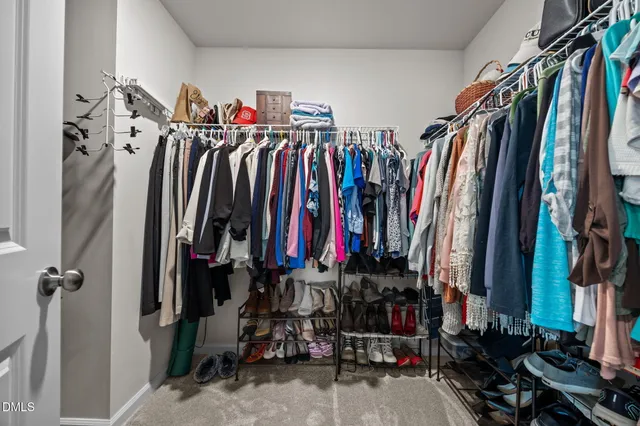 a view of walk in closet with clothes