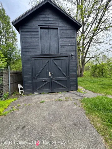 a view of small house with yard and garage