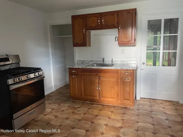 a kitchen with granite countertop a stove a sink and a microwave