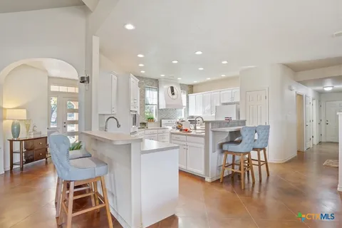 a kitchen with a dining table chairs and view living room