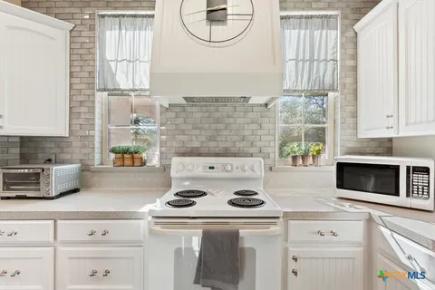 a white stove top oven sitting inside of a kitchen