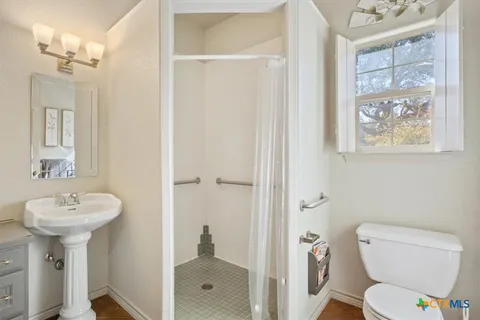a bathroom with a toilet sink and mirror