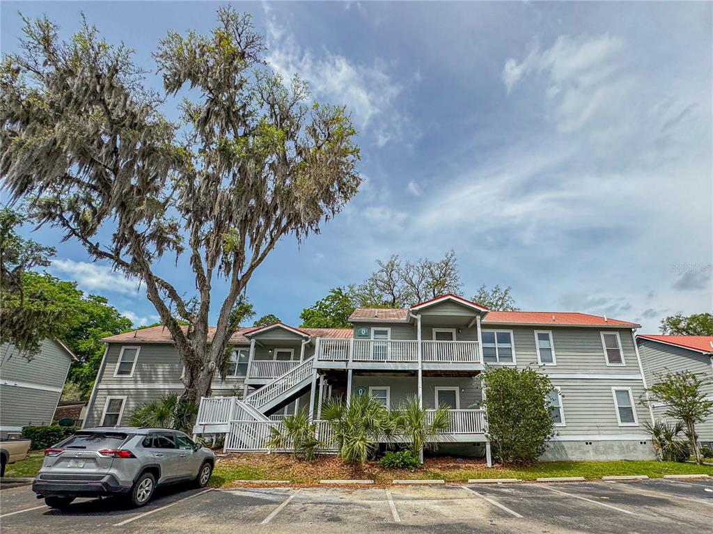 2905 Southwest Archer Road, Unit 4008 Gainesville, FL 32608 - Photo 1 of 1 a front view of a residential apartment building with yard
