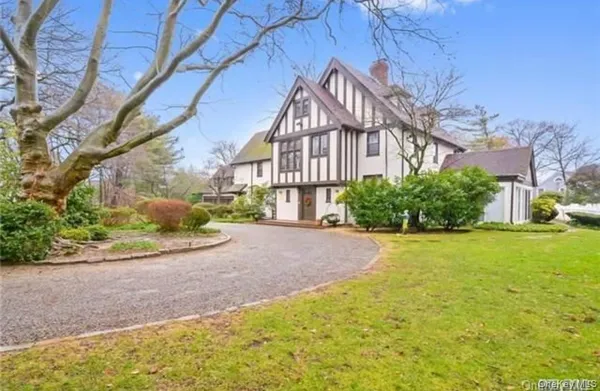 a front view of a house with a yard and potted plants