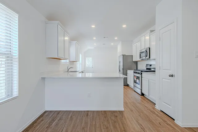 a kitchen with stainless steel appliances a refrigerator and a stove top oven