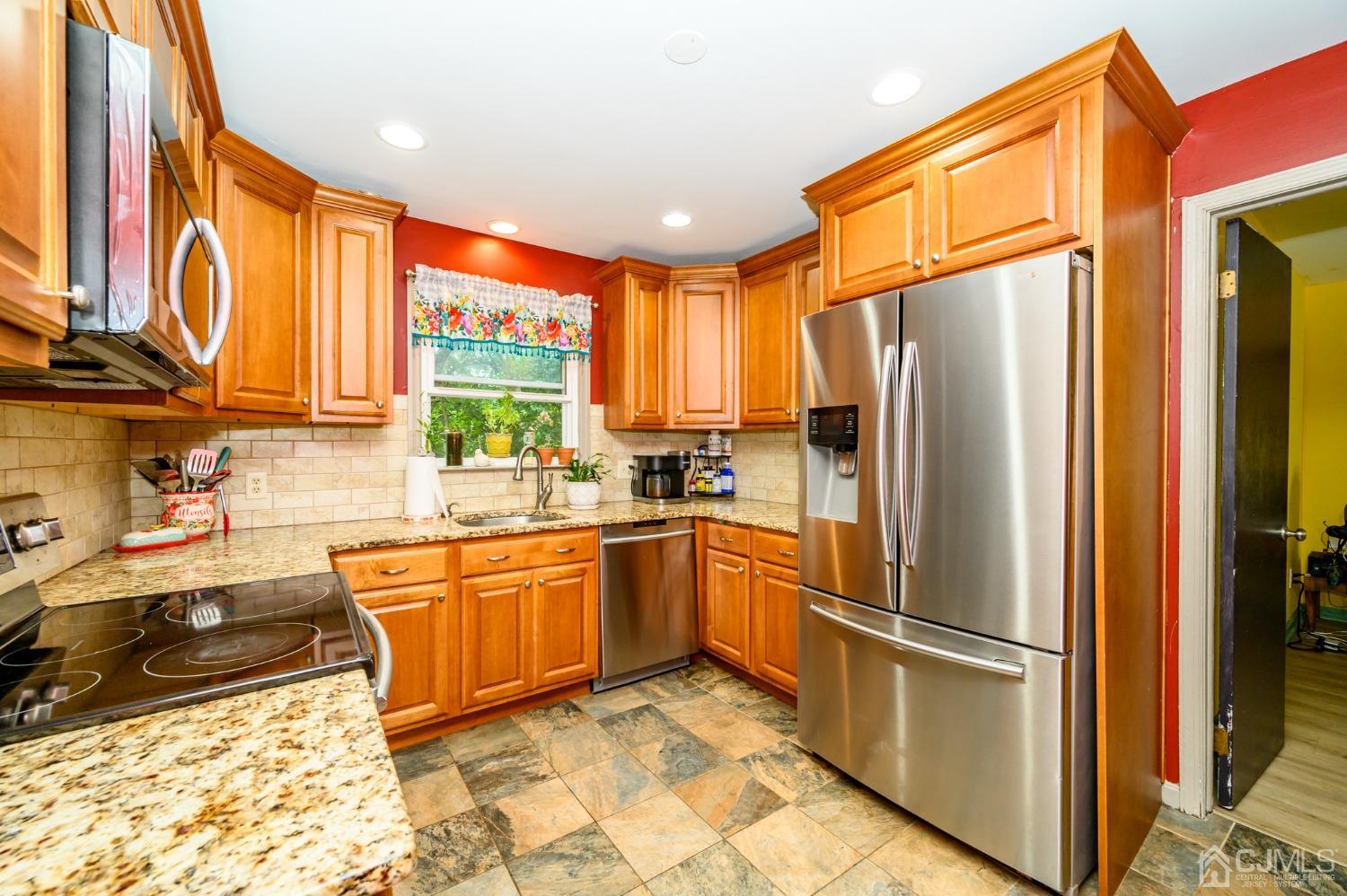 67 Hollow Road Glen Gardner, NJ 08826 - Photo 11 of 45 a kitchen with stainless steel appliances granite countertop a refrigerator a stove a sink dishwasher and wooden cabinets