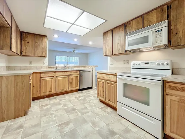 a large kitchen with stainless steel appliances granite countertop a sink and cabinets