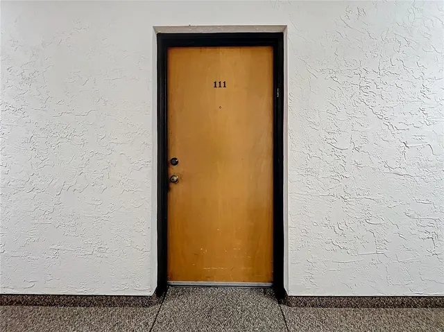 a view of an empty room with window and cabinet
