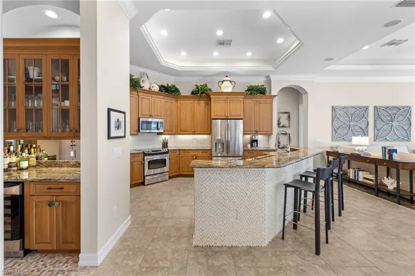 a kitchen with stainless steel appliances kitchen island granite countertop a table chairs sink and cabinets